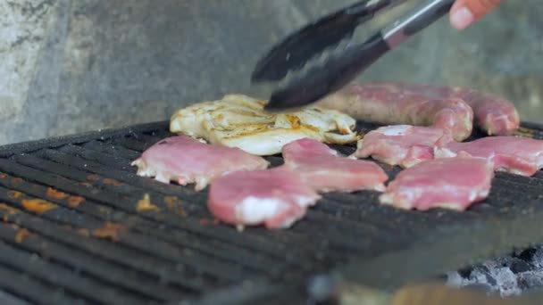 Het vlees op de grill buitenshuis draaien — Stockvideo