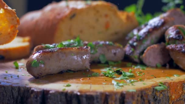 Соковиті смажені ковбаски на дерев'яній дошці — стокове відео