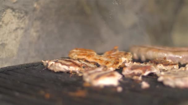 Het vlees op de grill buitenshuis draaien — Stockvideo