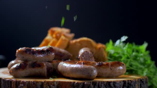 Salchichas asadas jugosas en una tabla de madera — Vídeos de Stock