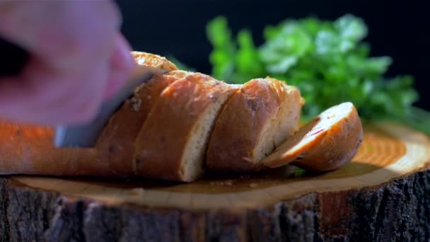 Vista de cerca de cortar pan en rodajas sobre tabla de cortar de madera . — Vídeo de stock