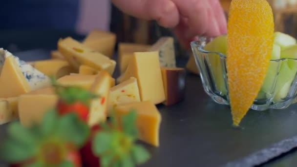 Beautiful arrangement of different types of cheeses on a black stone — Stock Video