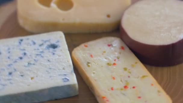 나무 판에 다양한 종류의 치즈가 회전합니다. — 비디오