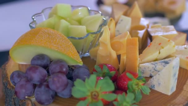 Différents types de fromages sur une planche en bois ont l'air très appétissants — Video