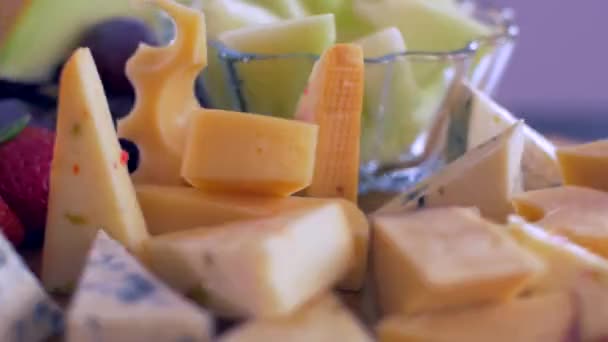 Различные виды сыров на деревянной доске вращаются по кругу — стоковое видео