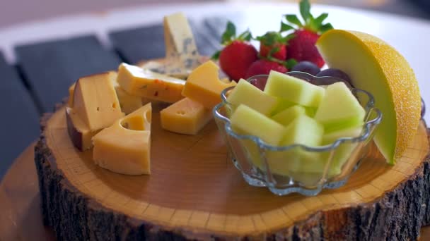 Красиве розташування різних видів сирів на дерев'яній дошці — стокове відео