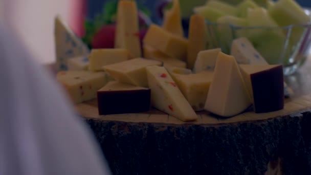 Different types of cheeses on a wooden board look very appetizing — Stock Video