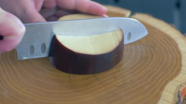 Κοπή του καπνιστά τυρί σε μια ξύλινη σανίδα — Αρχείο Βίντεο