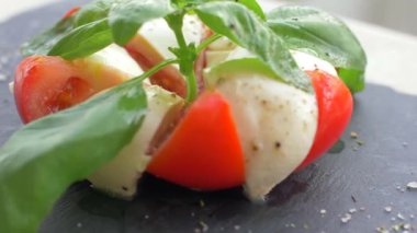 Güzel siyah bir arka plan üzerinde salata Caprese düzenlenmiştir. Yemeğinizin tadını çıkarın