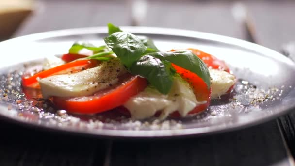 Vackert arrangerade Sallad Caprese på svart bakgrund. Njuta av din måltid — Stockvideo