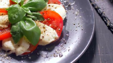 Güzel siyah bir arka plan üzerinde salata Caprese düzenlenmiştir. Yemeğinizin tadını çıkarın