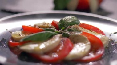 Güzel siyah bir arka plan üzerinde salata Caprese düzenlenmiştir. Yemeğinizin tadını çıkarın