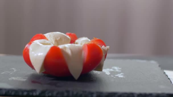 Basilicum toevoegen aan de Caprese salade. Zwarte achtergrond — Stockvideo