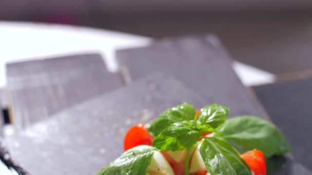 Salada lindamente arranjada Caprese em um fundo preto. Aproveite a sua refeição — Vídeo de Stock
