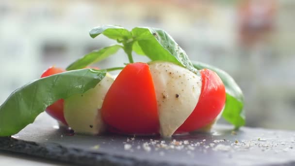 Güzel siyah bir arka plan üzerinde salata Caprese düzenlenmiştir. Yemeğinizin tadını çıkarın — Stok video