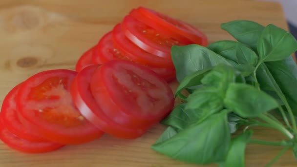Mãos cortando tomate na placa de corte de madeira — Vídeo de Stock