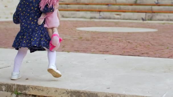 Uma menina loira com um vestido azul gosta dos pombos — Vídeo de Stock