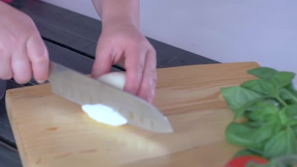 Tangan memotong keju mozzarella di papan potong kayu Top View — Stok Video