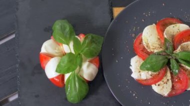 Güzel siyah bir arka plan üzerinde salata Caprese düzenlenmiştir. Yemeğinizin tadını çıkarın