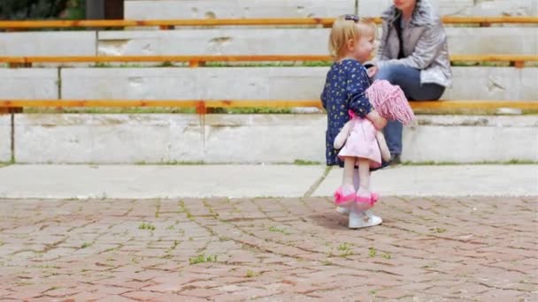 Mavi elbiseli küçük sarışın bir kız güvercinlerin tadını çıkarıyor. — Stok video