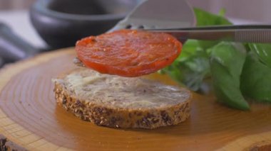 Bir sandviç üzerine kavrulmuş domates yerleştirin