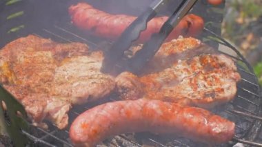 Izgara sosis ve domuz biftek ızgara tabakta, açık havada. Izgara yemek, barbekü