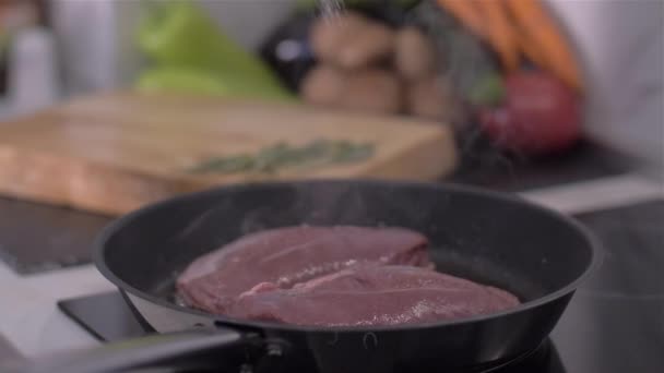 Le chef saupoudre de poitrine de canard salé dans une casserole 