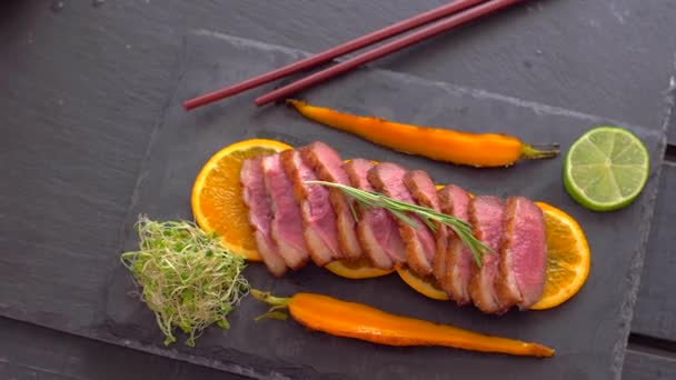 Un plat de poitrines de canard sur un canapé orange. Canard bien cuit . — Video