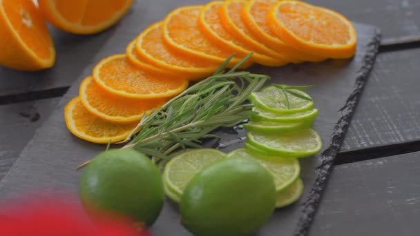 In Kreise aus Limette und Orange auf schwarzem Stein schneiden. Zubereitung von Cocktails — Stockvideo
