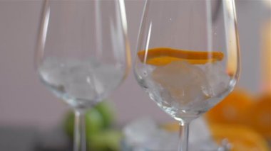 Portakal dilimini buzlu bir bardağa koymak. Kokteyllerin hazırlanması