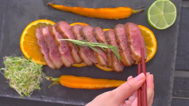 Ta en bit anka kött med pinnar att äta — Stockvideo