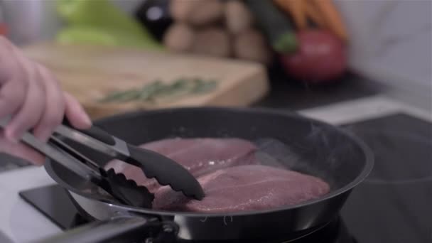 Fritovací šéfkuchař kachní prsa. Ruční překlopení maso v pánvi. — Stock video