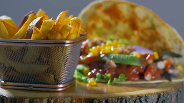 Ízletes mexikói élelmiszer-burrito és sült burgonya szolgált egy fából készült hajón — Stock videók