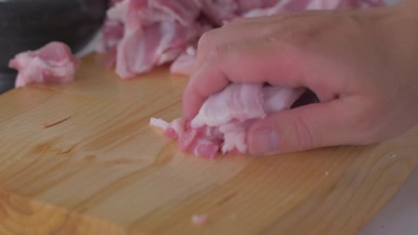 Chef corta trozos de tocino crudo con un cuchillo afilado en la tabla de madera — Vídeos de Stock