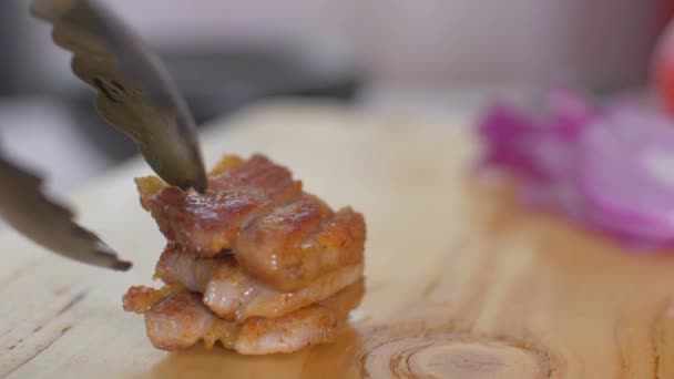 Cutting the bacon with a knife on a wooden board — Stock Video