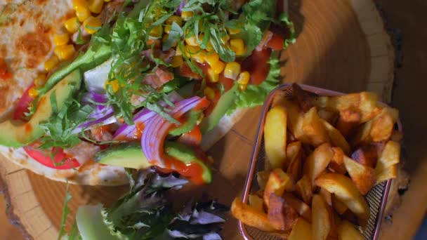 Läckra mexikanska mat burrito och stekt potatis serveras på en trä kartong — Stockvideo
