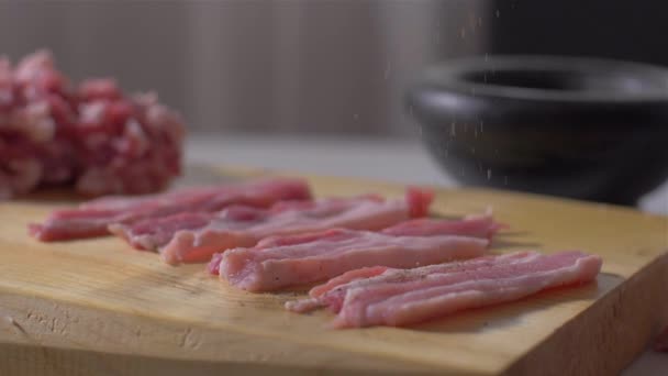 Espolvorear tocino crudo con pimienta y sal — Vídeos de Stock