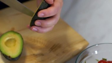 Bir kadın el onu sağlıklı salata için avokado o keser