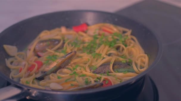 Adding parsley to a pan with seafood and mussels — Stock Video