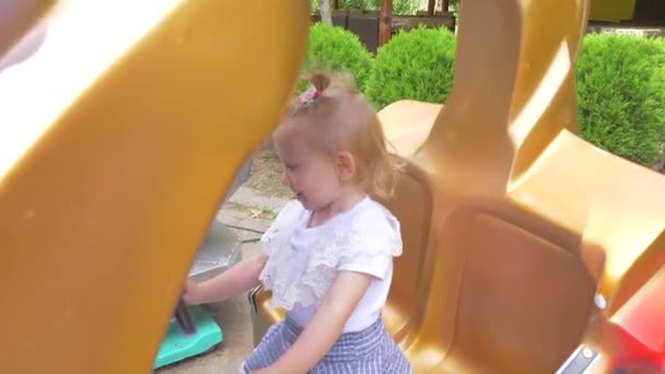 Schattige lachende babymeisje swingen op een schommel in de zomerdag. Slow motion. — Stockvideo