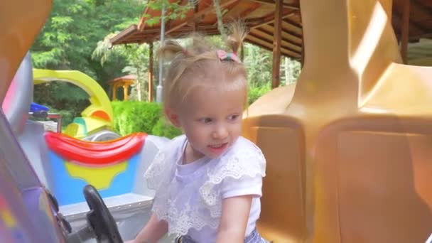 Bonito sorrindo pequena menina balançando em um balanço no dia de verão. Movimento lento . — Vídeo de Stock