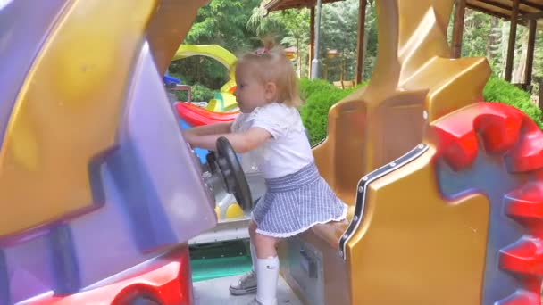 Bonito sorrindo pequena menina balançando em um balanço no dia de verão. Movimento lento . — Vídeo de Stock