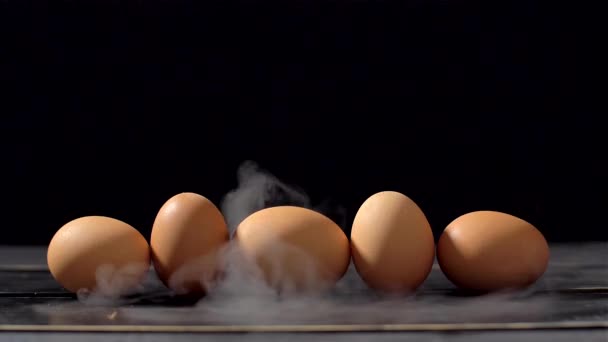 Ahumador en cámara lenta sobre fondo negro y huevos — Vídeo de stock