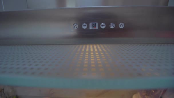 Child arm switches on and off light on the modern kitchen extractor. — Stock Video