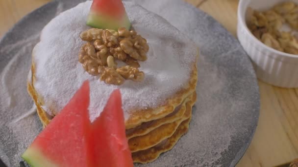 Decorating American pancakes with juicy watermelon and walnuts — Stock Video