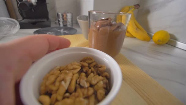 Gieten van walnoten in een verwarmde pan. Amerikaanse pannenkoeken maken — Stockvideo