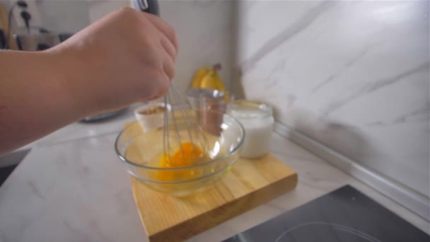Het breken van de eieren met een garde. Pannenkoeken maken. — Stockvideo