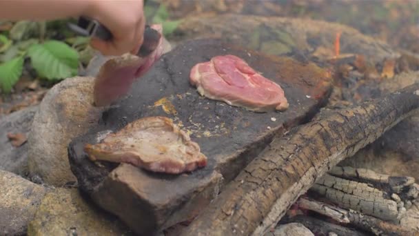 Asar carne sobre una piedra de fuego — Vídeo de stock