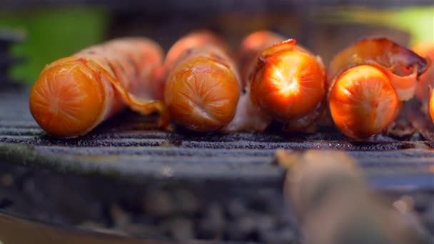 Grillezett kolbász szalonnával. Kolbászok szalonnás sütve a grill — Stock videók