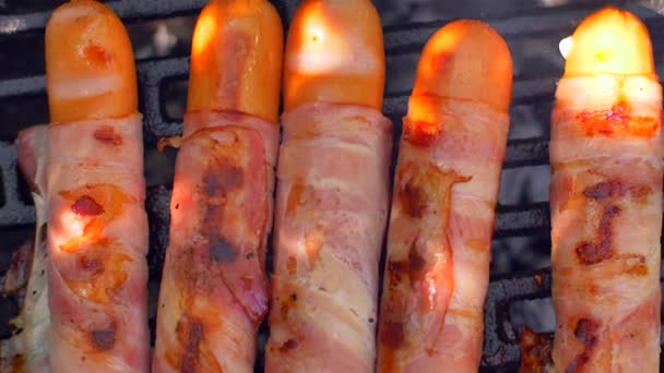 Жареная колбаса с беконом. Сосиски с жареным беконом на гриле — стоковое видео
